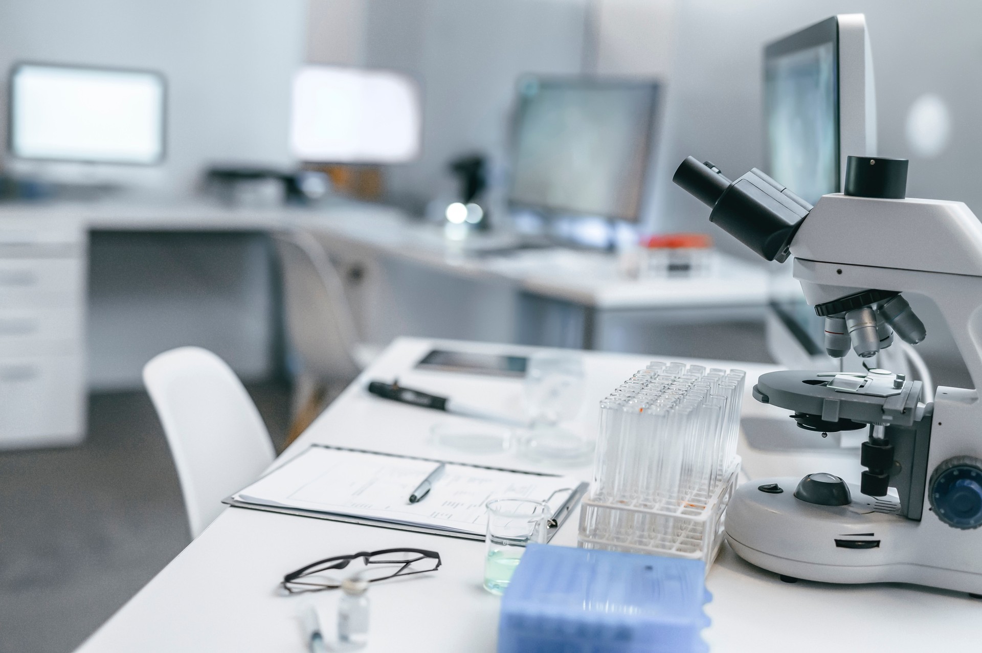 Modern lab, test center or chemistry laboratory with scientific microscope, tubes and equipment at a desk for analysis, experiments and clinical trials. Copy space in an empty forensic research room